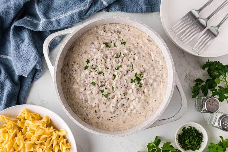 ground beef stroganoff served in a large white pot.