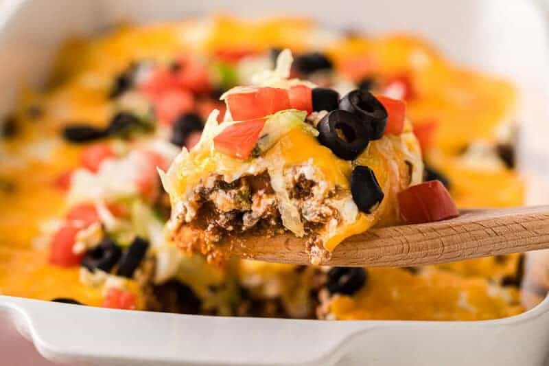 Taco Casserole being served on a wooden spoon.