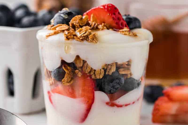 closeup of a Yogurt Parfait with granola, blueberries and strawberries.