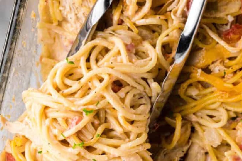 Chicken Spaghetti Casserole being served with tongs.