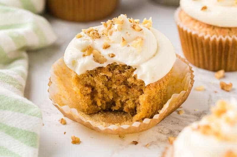 closeup of a Carrot Cake Cupcake with a bite taken out of it.