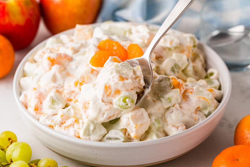 serving the Fruit Salad out of a white bowl.