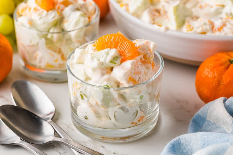 serving the Creamy Fruit Salad in clear glasses.