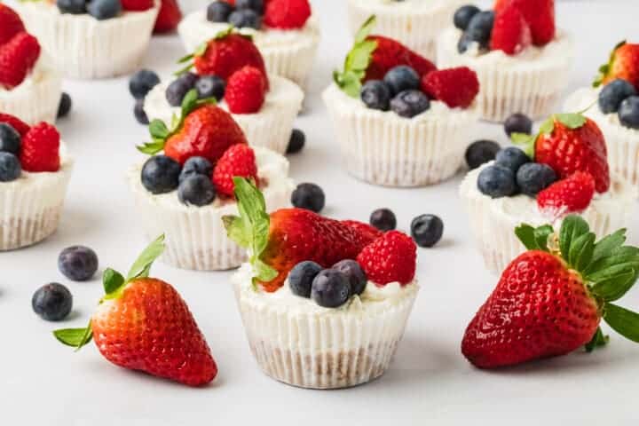 No Bake Mini Cheesecakes topped with blueberries and strawberries.