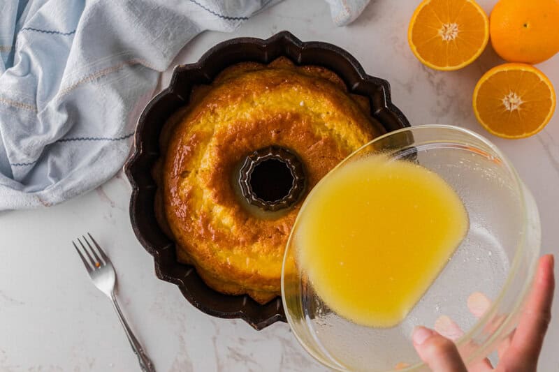 pouring the Orange Juice Glaze over the cake.