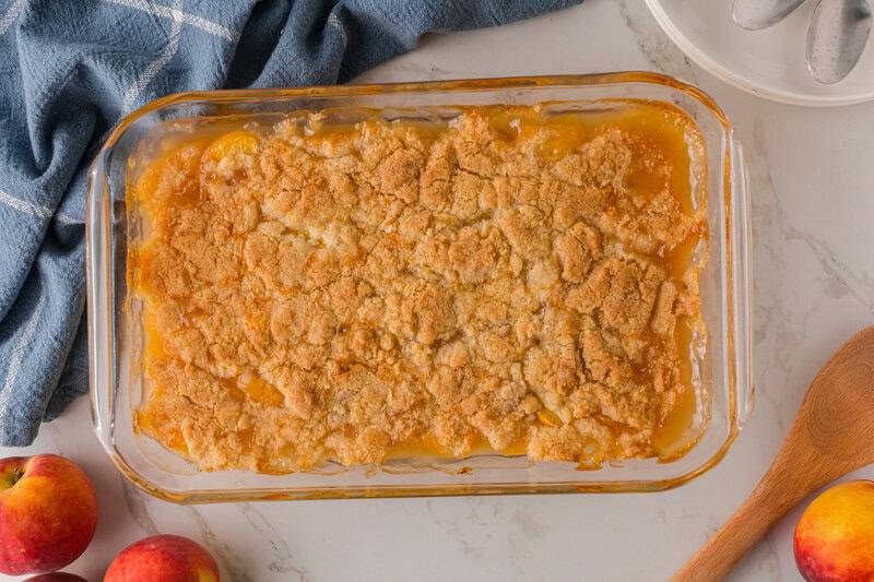 Peach Cobbler baked in a clear baking dish.