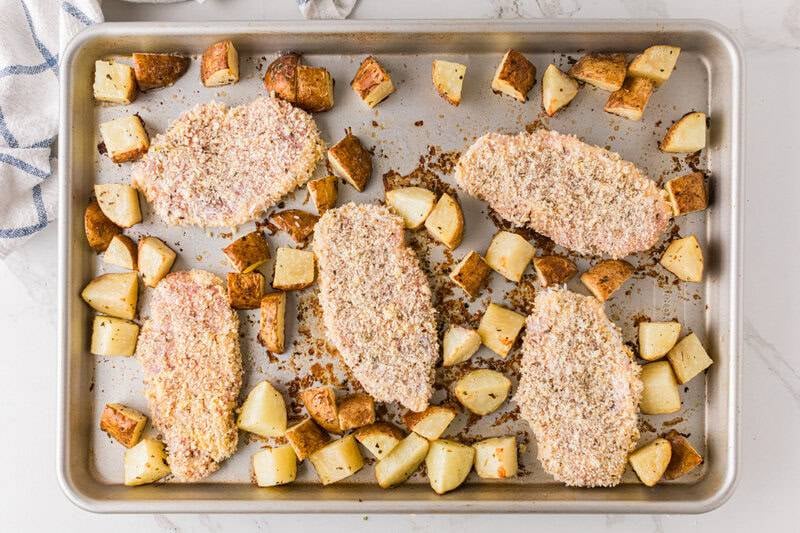 pork chops and potatoes on the baking sheet.