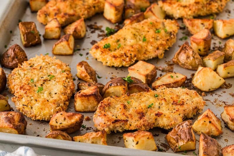 closeup of the pork chops and potatoes on the sheet pan.