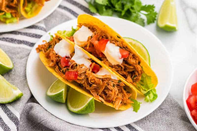 Slow Cooker Cilantro Lime Chicken Tacos served on a white plate.