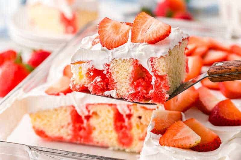 serving a slice of the Strawberry Poke Cake.