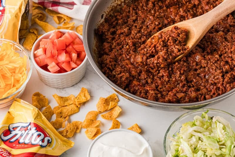 ground beef in the pan with the Walking Taco ingredients around it.