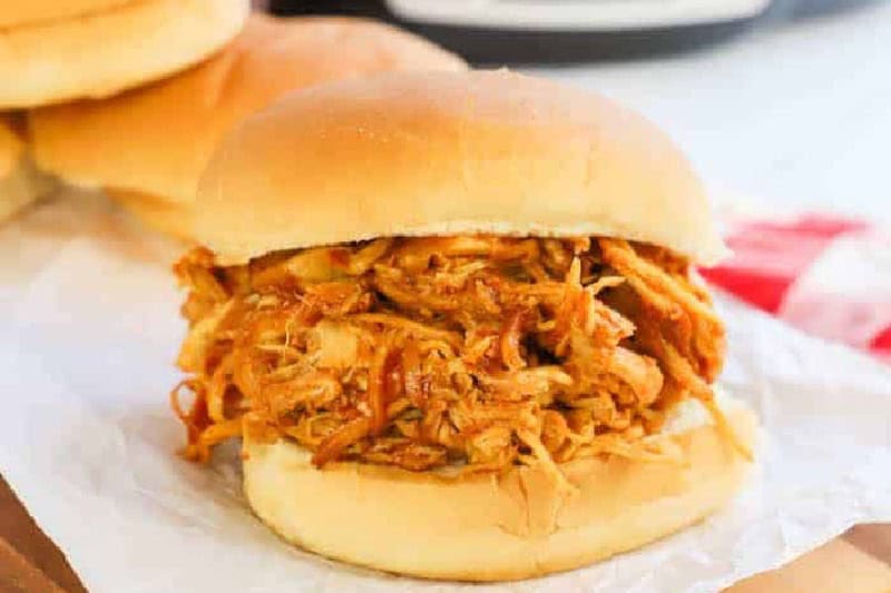 Slow Cooker BBQ Chicken Sandwiches on parchment paper.