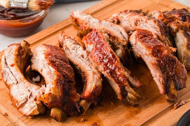 closeup of the individual ribs served on a wooden board.