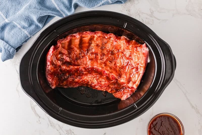 the ribs placed in the slow cooker.