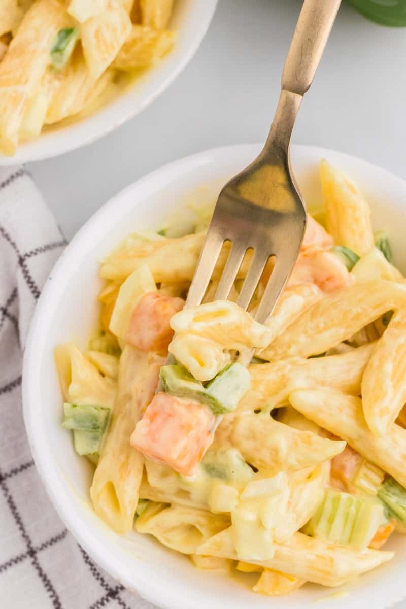 using a fork to eat the pasta salad.