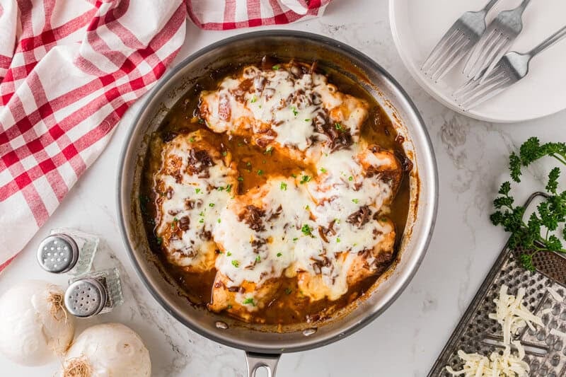 topping the chicken with cheese and cooking.