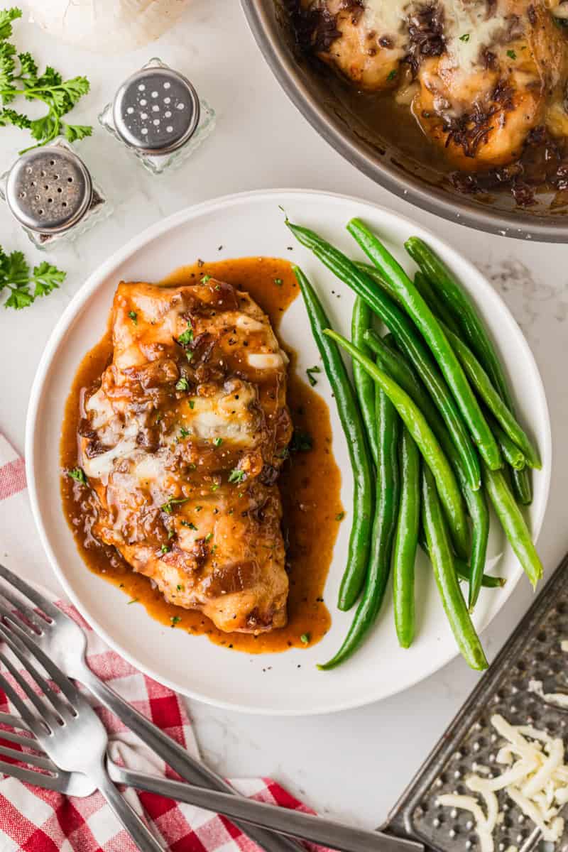 French Onion Chicken served on a white plate with green beans.