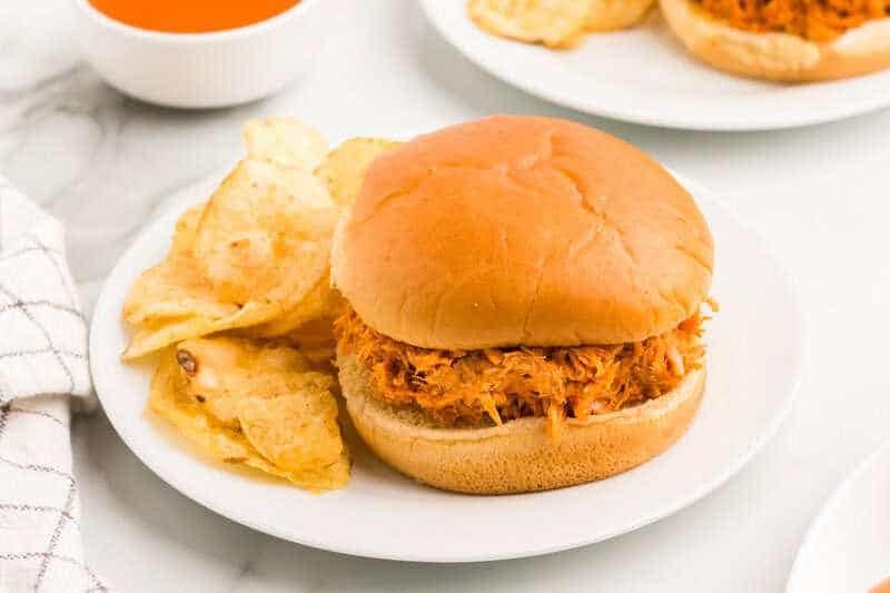 Slow Cooker Buffalo Chicken Sandwiches served with chips.