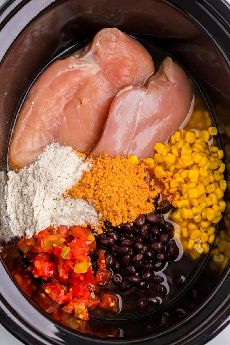 all ingredients for the slow cooker chicken taco soup inside the slow cooker.