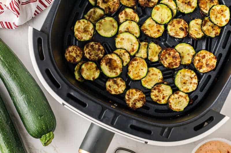 Crispy air fryer zucchini slices on a plate as a light BBQ side.