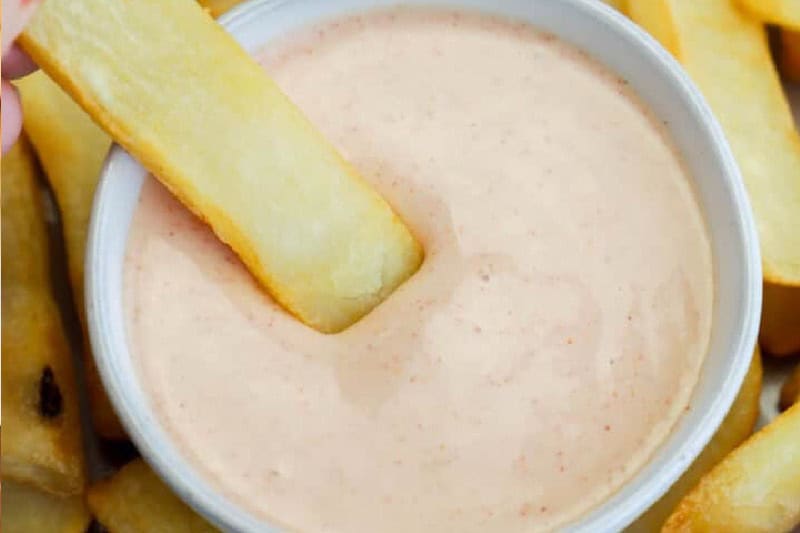 Homemade fry sauce in a small bowl next to fries and burgers.