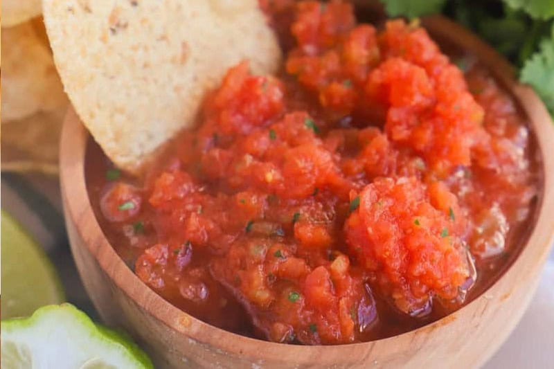 Fresh blender salsa in a bowl with tortilla chips for a BBQ spread.