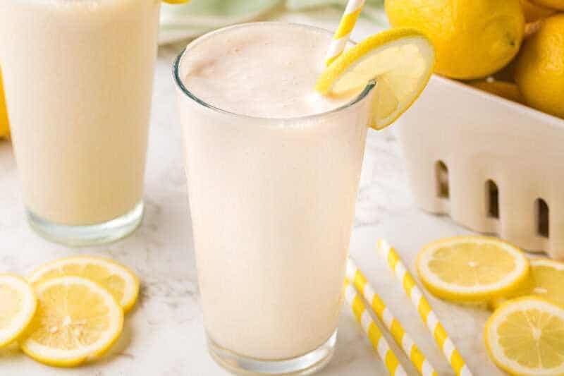 Glass of Frosted Lemonade with a slice of lemon.