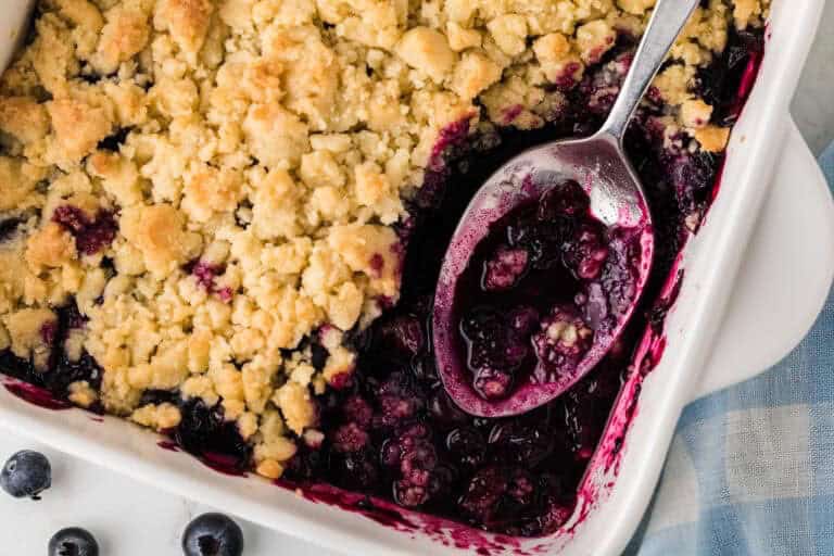 top-down view of the Blueberry Cobbler being served out of a white baking dish.