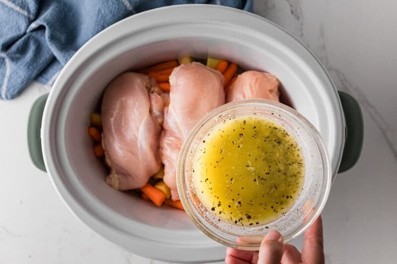pouring the butter and seasoning over the chicken and potatoes.