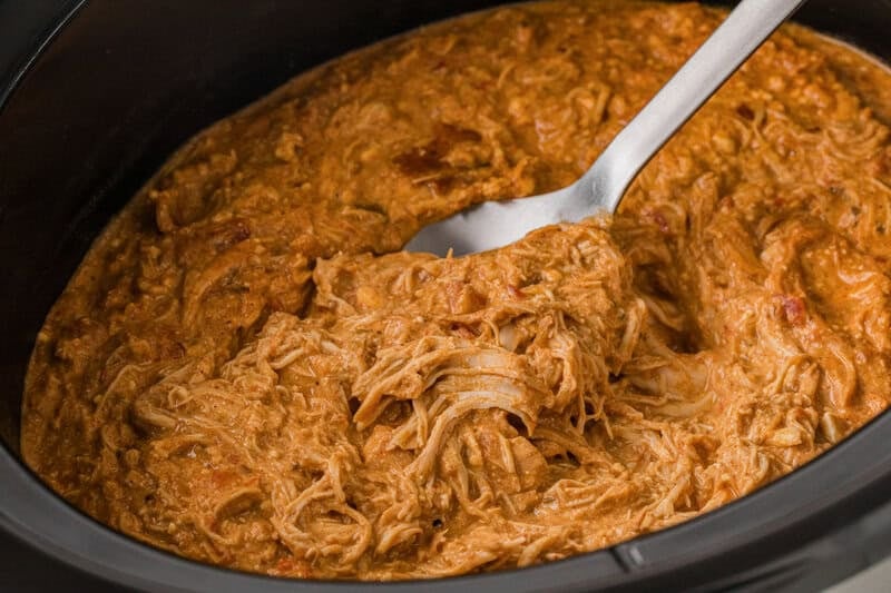 mixing the Queso Chicken in the slow cooker.
