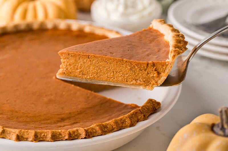 serving a slice of the pumpkin pie.