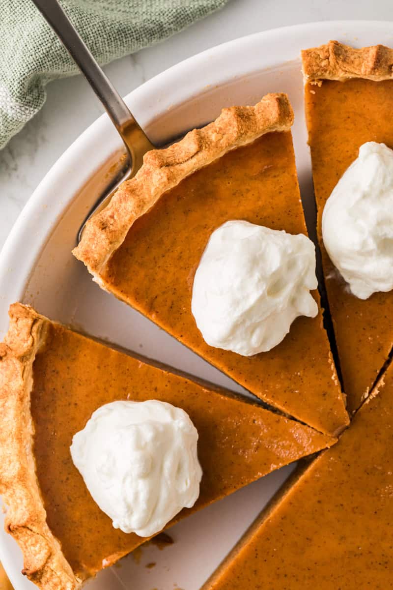 closeup of slices of the Pumpkin Pie with whipped cream on top.