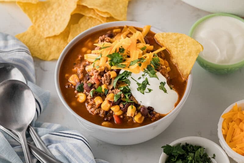 bowl of the Taco Soup topped with sour cream, cheddar cheese and cilantro.