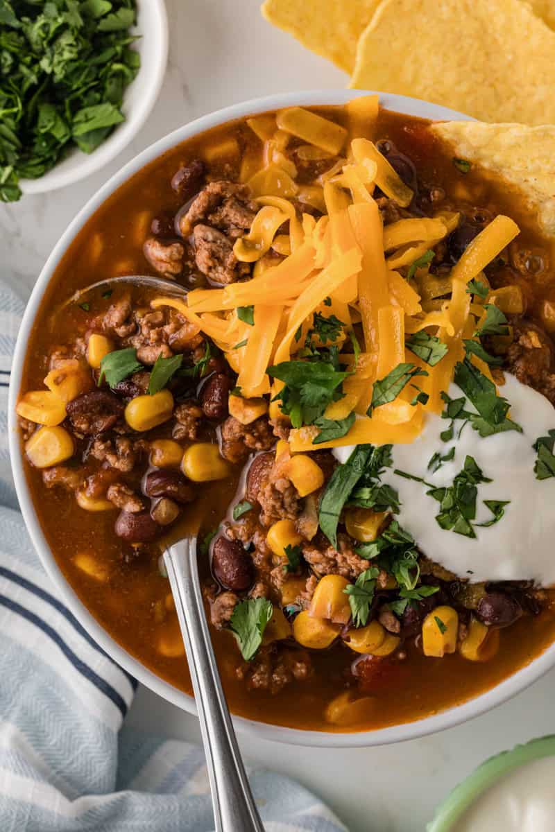 closeup of the taco soup served with cheddar cheese and sour cream.