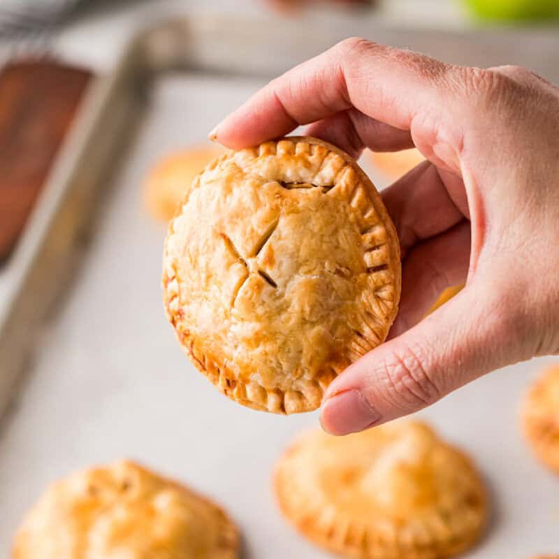 holding an apple pie cookie in hand.