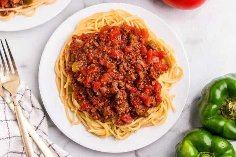 top-down view of spaghetti sauce served on top of spaghetti.