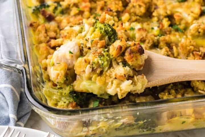 serving the Chicken Stuffing Casserole out of a clear baking dish.