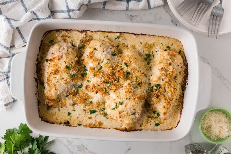 baked Caesar Chicken in a white baking dish.
