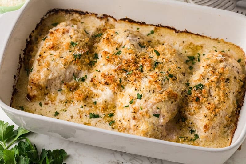 Baked Ceasar Chicken baked in a white baking dish.
