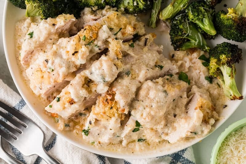 Caesar Chicken sliced and served on a plate with broccoli.