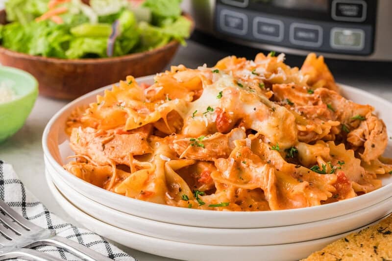 serving the Creamy Chicken Pasta on a white plate.