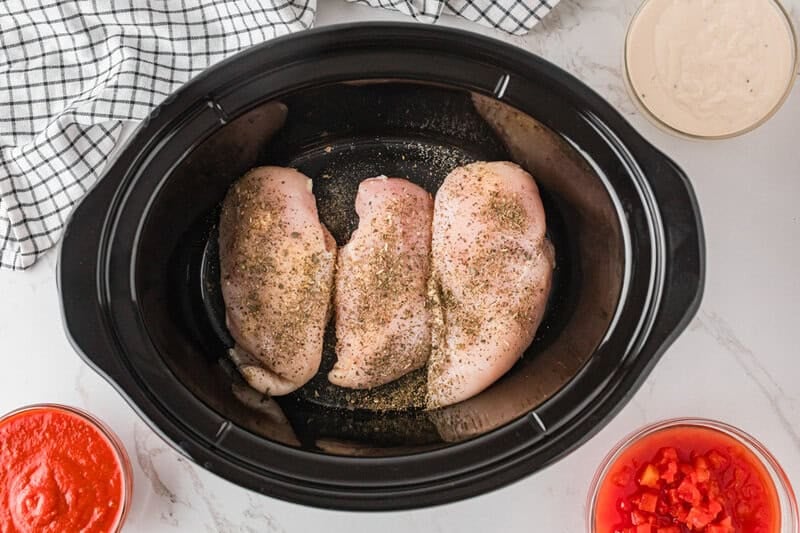 top-down view of the chicken breasts seasoned in the slow cooker.