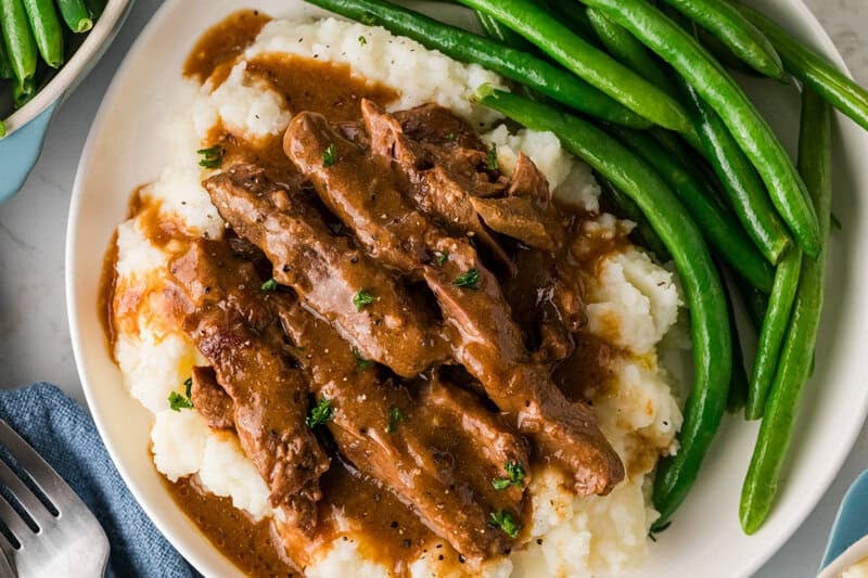 top-down view of the Steak and Gravy served on a bed of mashed potatoes.