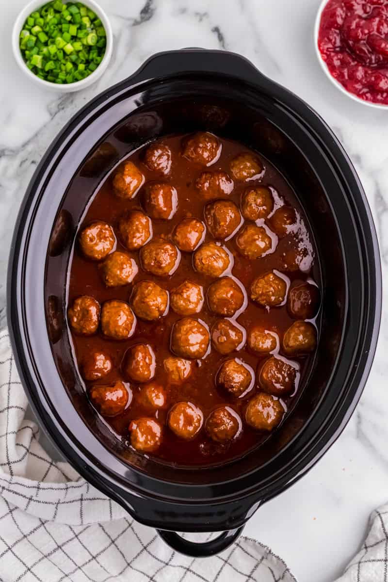 top-down view of the meatballs in the slow cooker.