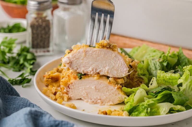 the Swiss Chicken Sliced in half on a plate with salad.