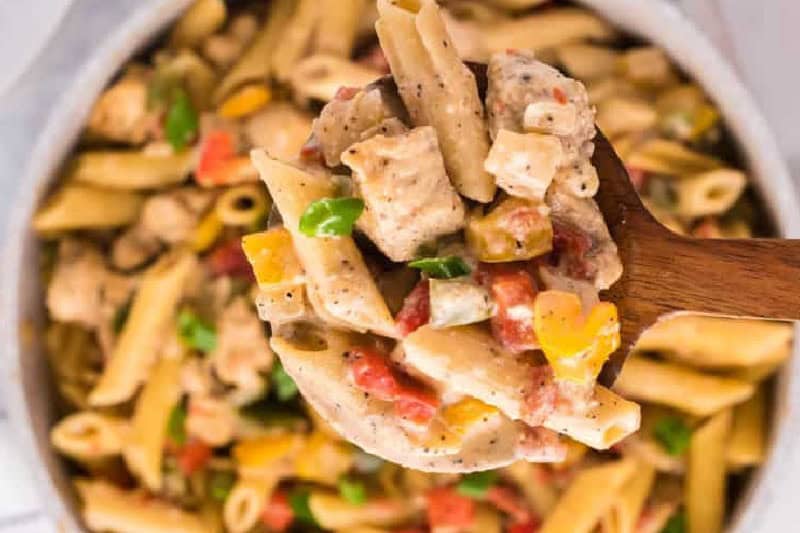 closeup of the Chicken Fajita Pasta being served on a wooden spoon.