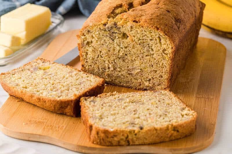3 Ingredient Banana Bread sliced on a wooden serving board.