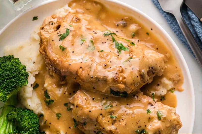 top-down view of the smothered Pork Chops served on a white plate.