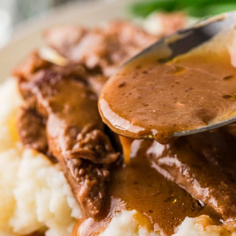 spooning some more gravy over the steak strips.