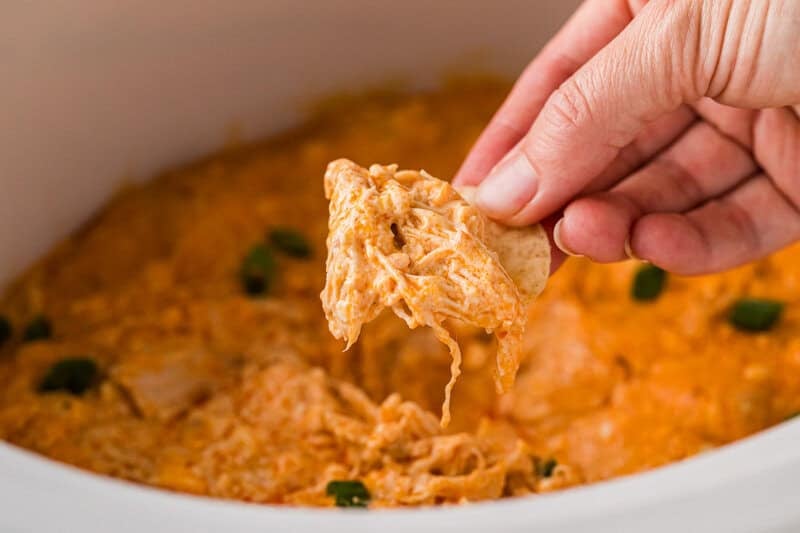 dipping a tortilla chip into the Buffalo Chicken Dip.